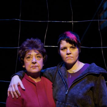 Close up of Maria Vacratsis and Michaela Washburn in front of a fence looking forward