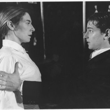 Close up of Tracey Ferenz and Jordan Pettle facing each other. Jordan has their hand on Tracey’s arms. Black and white image